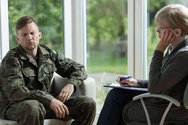 Psychologist talking with despair soldier