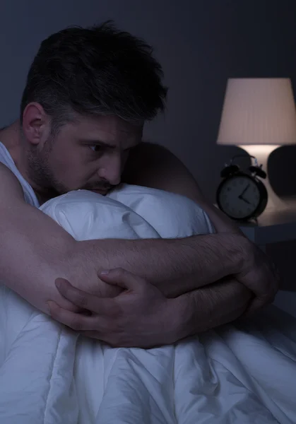 Unhappy thoughtful man in bed