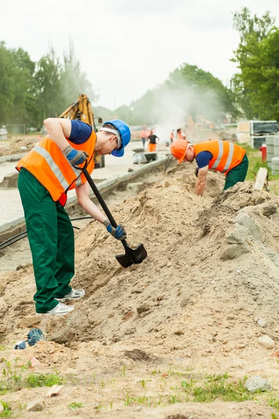 Workers digging on a platform