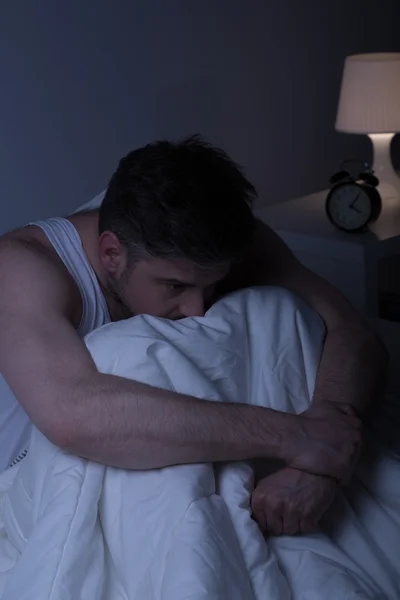 Depressed man alone in bed