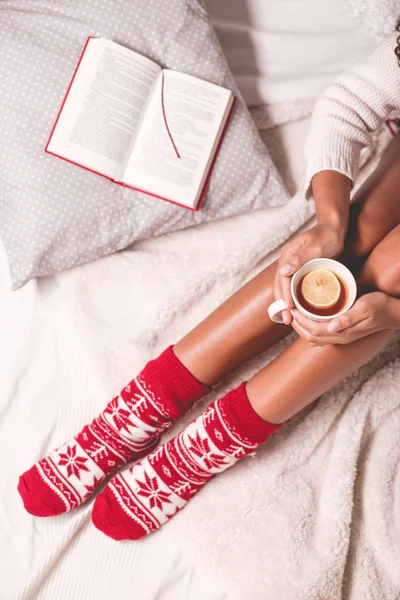Woman in winter socks with cup of tea
