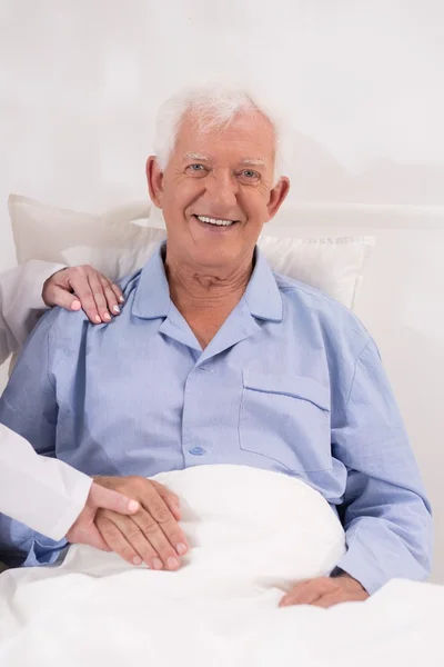Smiling elderly patient in bed