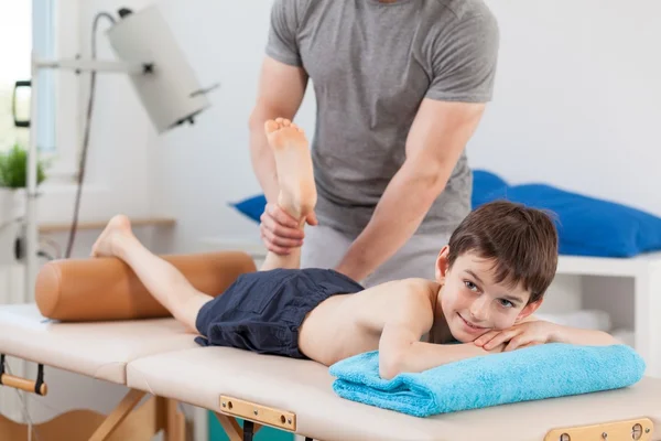 Boy lying on physiotherapy table