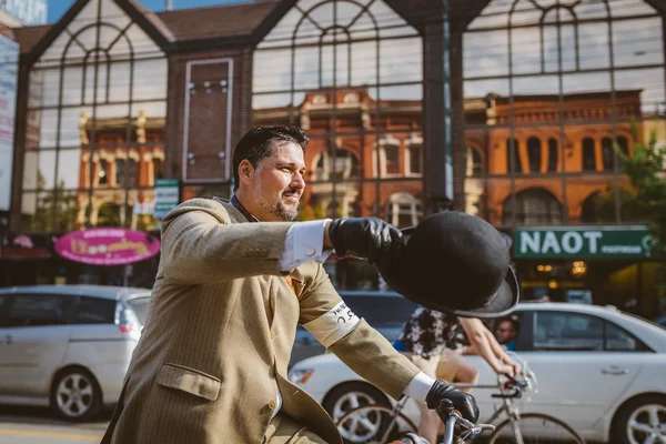 Toronto, Canada - September 20, 2014: Unidentified participants of Tweed Ride Toronto in vintage style clothes riding on their bicycles. This event is dedicated to the style of old England