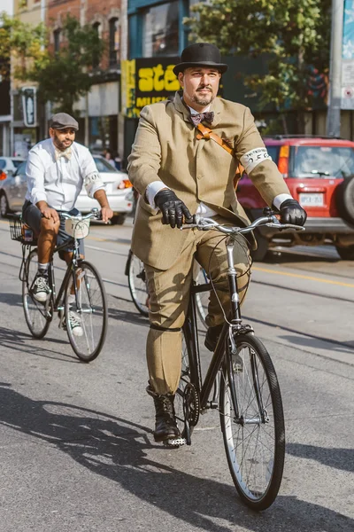 Toronto, Canada - September 20, 2014: Unidentified participants of Tweed Ride Toronto in vintage style clothes riding on their bicycles. This event is dedicated to the style of old England