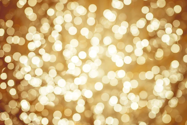 Golden background with natural bokeh defocused sparkling lights. Colorful metallic texture with twinkling lights. Bright and vivid colors