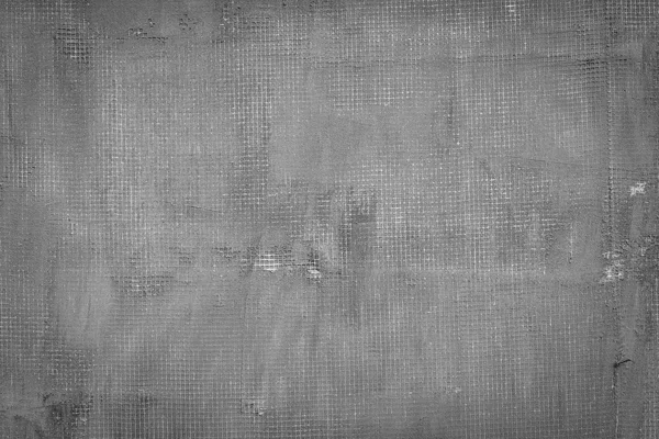 Cracked dark grey concrete wall with net, holes, splits and stains. Texture cement background