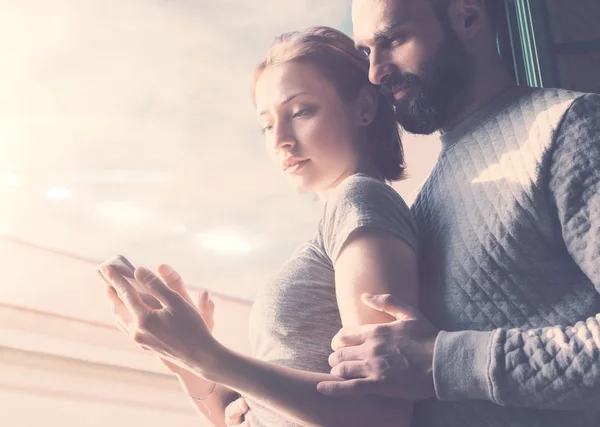 Adult couple romantic journey. Photo woman and bearded man using mobile phone. Girl touching screen contemporary smartphone. Horizontal, film effect.