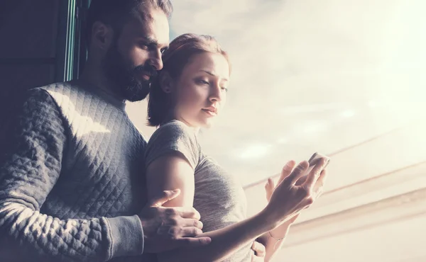 Adult couple romantic holiday. Photo woman and bearded man using mobile phone. Girl touching screen contemporary smartphone. Horizontal, film effect.