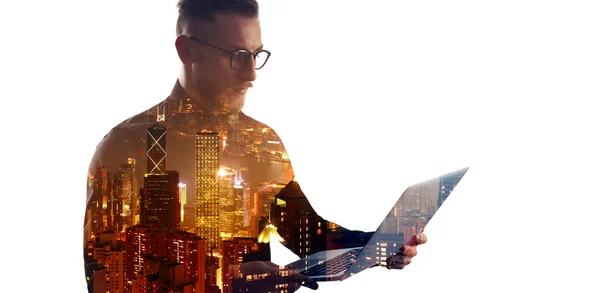 Double exposure bearded businessman wearing black shirt and glasses.Banker holding contemporary notebook hands,using online banking.Modern skyscraper city at night background.Wide mockup, isolated