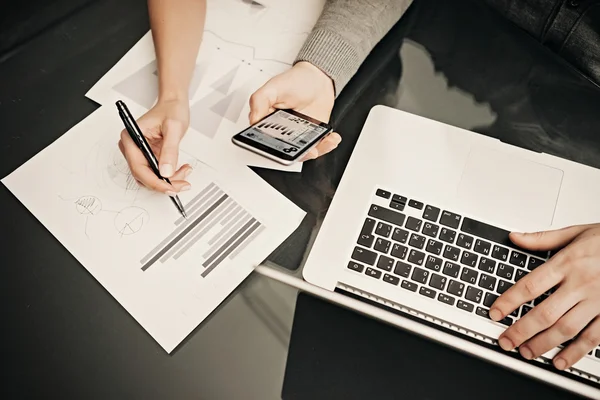 Business situation,team work process.Photo female hand holding pen. Man using smartphone and modern laptop,analyze info on screen. Working process office.Discussion idea startup.Horizontal.Film effect