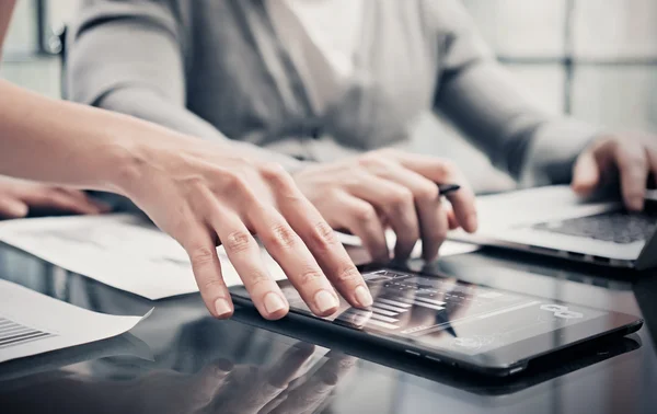 Analytical department working process.Closeup picture woman showing business reports modern tablet screen.Statistics graphics screen.Banker holding pen signs documents,discussion startup.Film effect