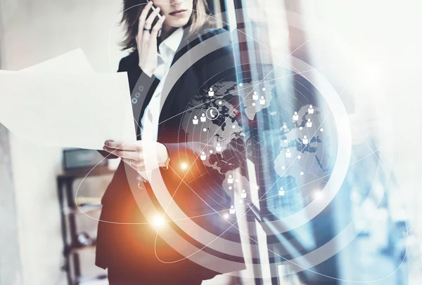 Photo business woman wearing black suit,talking smartphone and holding papers hands.Open space loft office.Panoramic windows background.Connections world wide interfaces.Horizontal,flares.Film effect.