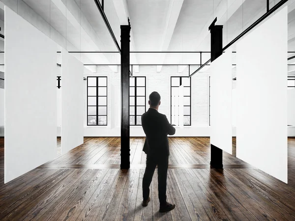 Gentleman Modern museum expo loft interior.Open space studio.Empty white canvas hanging.Wood floor,bricks wall,panoramic windows.Blank frames ready for bussiness information.Horizontal mockup.