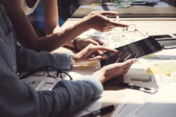 Girl Showing Screen Digital Tablet Hand.Project Managers Researching Process.Business Team Working Startup modern Office.Analyze market stock.Using electronic devices,papers,notes wood table.Blurred.