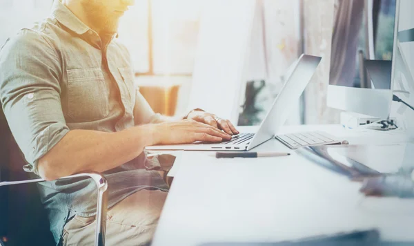 Bearded Hipster Working wood Table Laptop Modern Interior Design Loft Office.Man Work Coworking Studio,Use contemporary Notebook.Blurred Background.Creative Business Startup Idea.Flares,film effect.