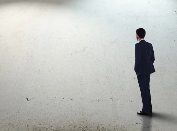Man in suit standing on concrete floor
