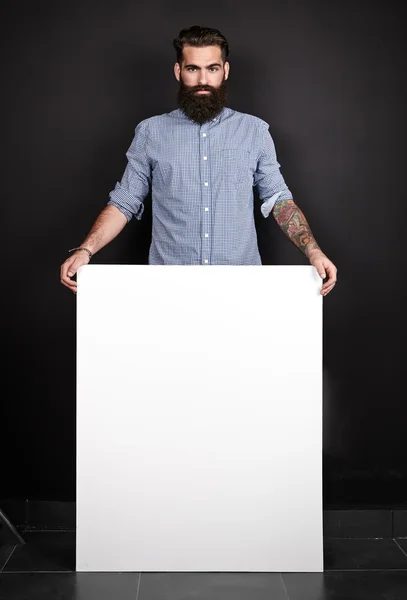 Bearded man holding blank poster.