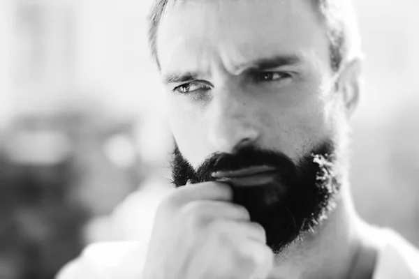 BW portrait of a bearded man wearing white tshirt and thinking