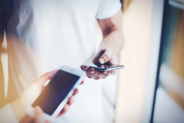 Man and woman holding in hands their gadgets