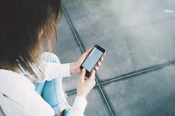 Woman holding her smartphone in hands