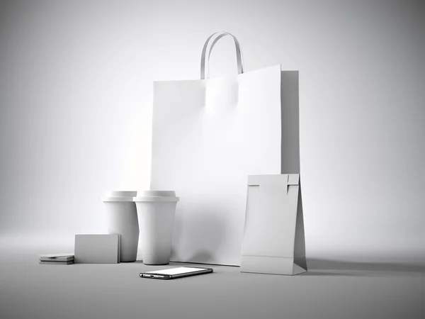 Set of white blank shopping bag, two coffee cups, business cards and generic design smartphone. Light background. 3d render