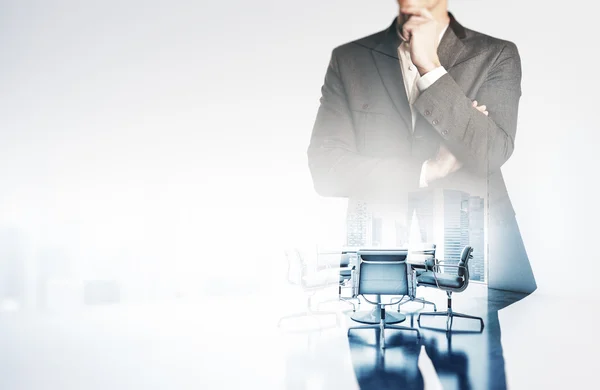 Photo of businessman wearing suit. Double exposure,  empty meeting room on the background. Horizontal