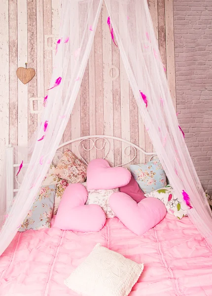 Four-poster bed with pink pillows