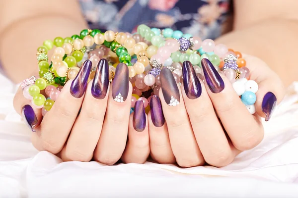 Hands with long artificial manicured nails