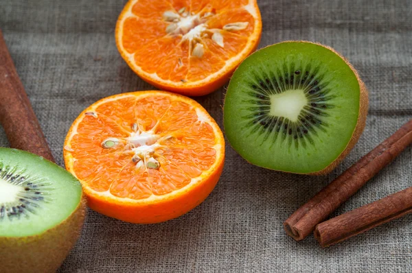 Fruit set - orange tangerine half,  kiwi and cinnamon sticks on hessian linen fabric cloth