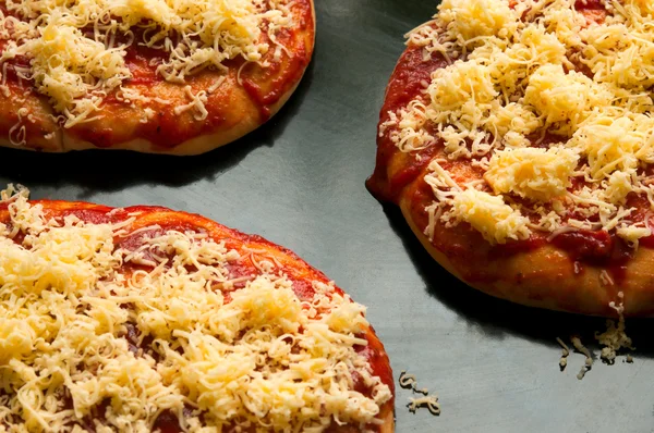 Mini pizzas or small pellets covered with cheese close-up macro