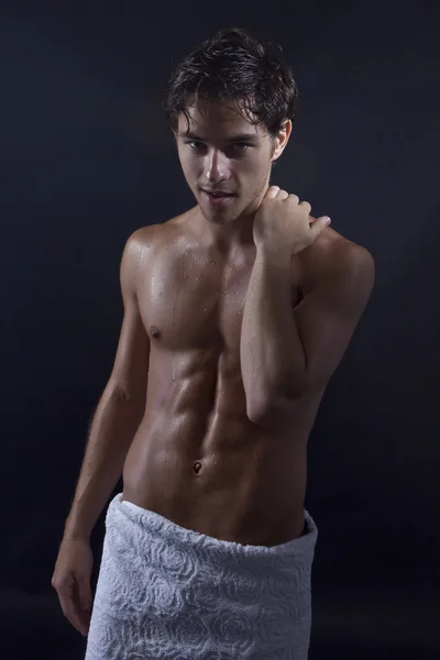 Handsome young man with towel around waist