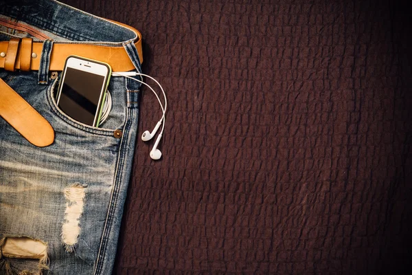 Texture background of jeans , belt detail with mobilephone and e
