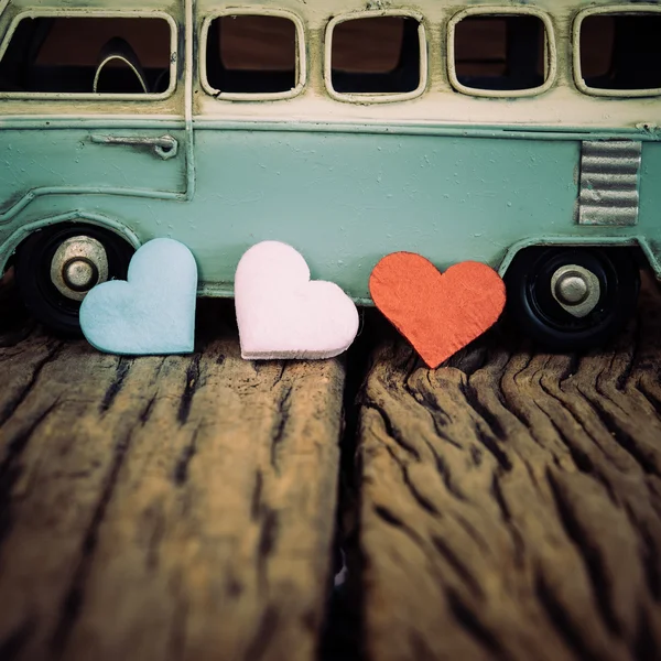 Hearts with part of vintage blue van background on old wooden ta