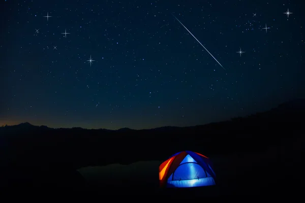 Camping tent under stars at night