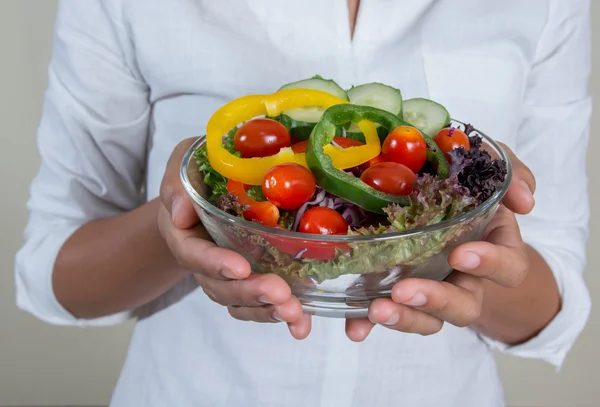 Beautiful woman holding a bowl of fresh veggie salad