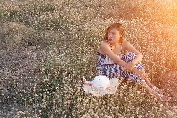 Sexy Beautiful woman sitting in flower field sadly and lonelines
