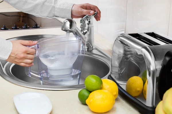 Man fills filter jug with tap water