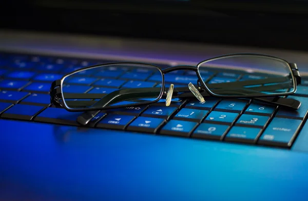 Eyeglasses on laptop keyboard.