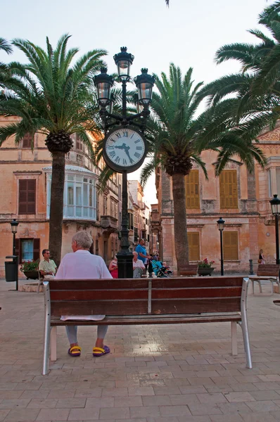 Menorca, Balearic Islands: a man on a bench in the town square of Placa d\'Alfons III, Ciutadella