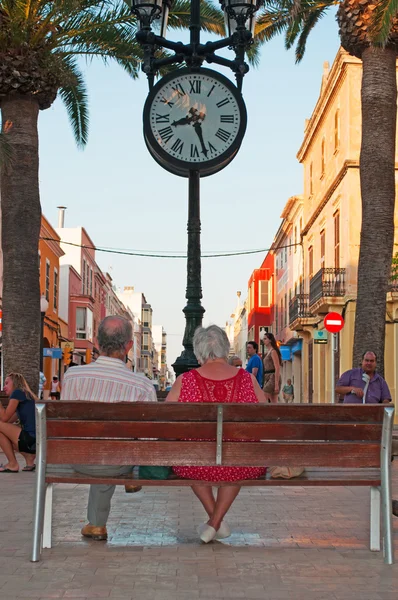 Menorca, Balearic Islands: a couple on a bench in the town square of Placa d\'Alfons III, Ciutadella