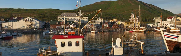 Iceland: view of the harbour and the city of Husavik at sunset