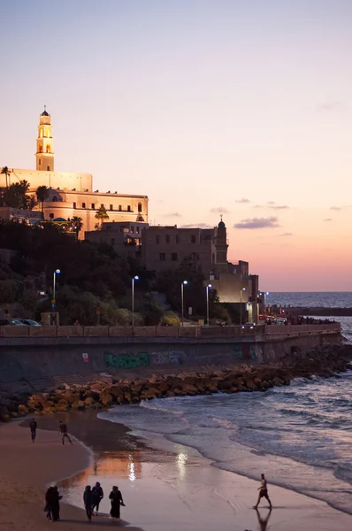 Jaffa, Israel: the minaret of Al Bahr Mosque, the bell tower of St. Peter\'s Church and the beach at sunset