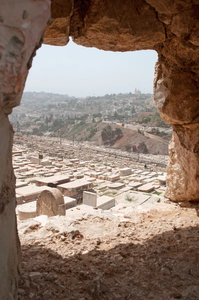 Jerusalem: view of the graves of the Jewish Cemetery trough a wall and skyline