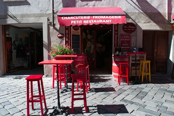 Aosta, Italy: the red tables and chairs of a restaurant in the center of the city