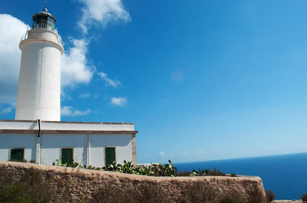 Fomentera, Balearic Islands: a stone wall and view of La Mola Lighthouse