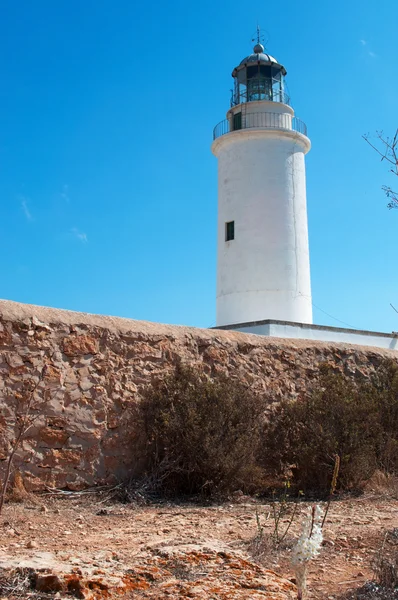 Fomentera, Balearic Islands: a stone wall and view of La Mola Lighthouse