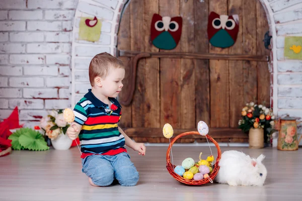 Happy boy with rabbit and easter eggs