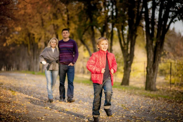 Beautiful family walking in autumn park