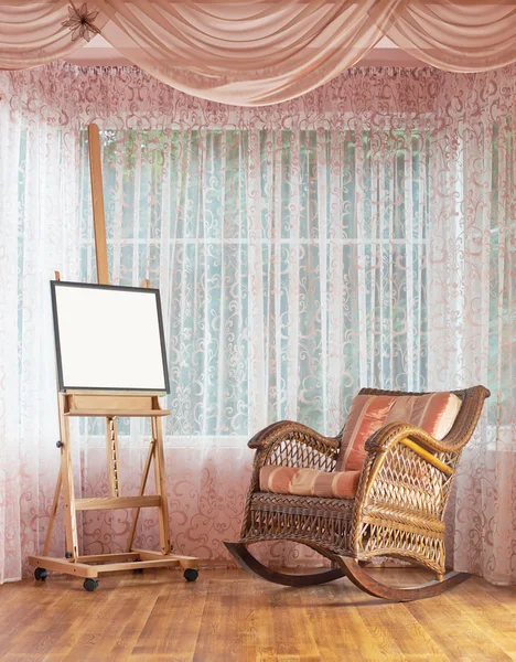 Wooden easel and wicker rocking chair